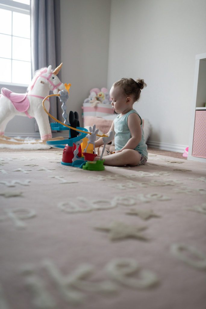 baby girl playing with toys in her room