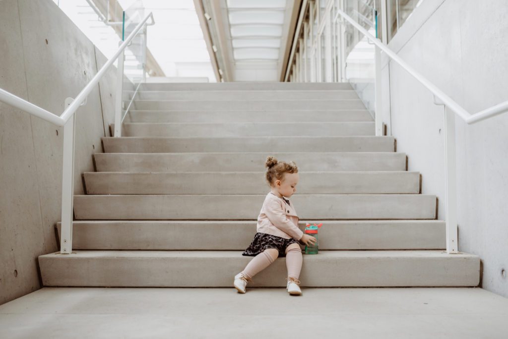 child sitting on concrete stairs outside