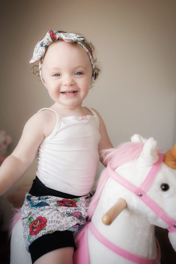 child smiling on unicorn rocking horse